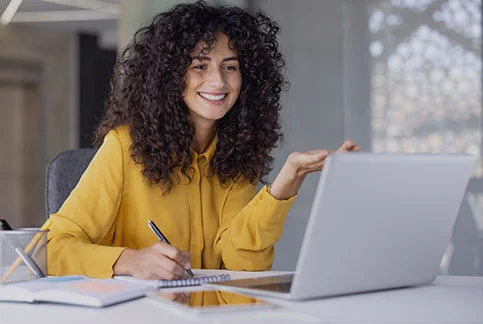 Lächelnde Erzieherin, die an einer Online-Schulung für das KITA-Management teilnimmt.